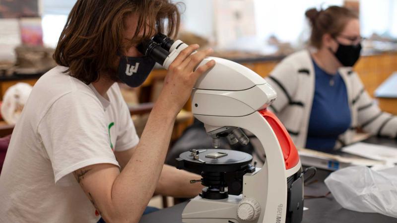 地球科学学生正在观察显微镜 