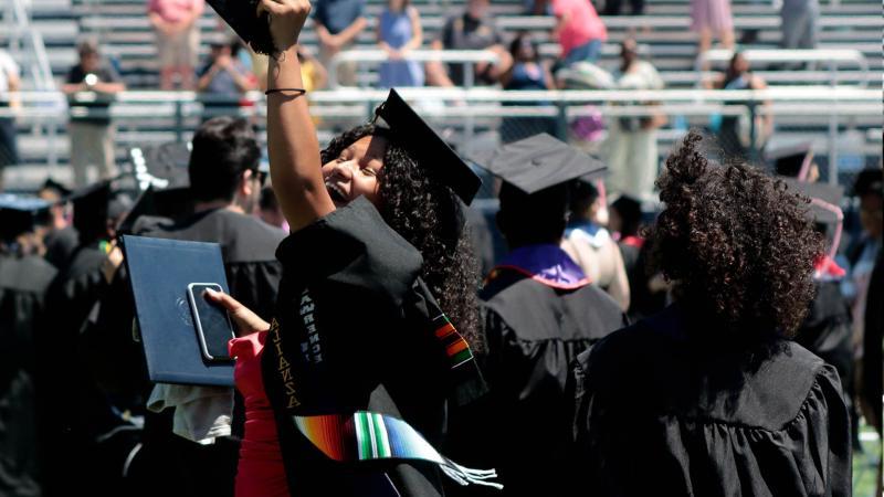 在班塔碗举行的毕业典礼上，快乐的毕业生在空中拿着学位
